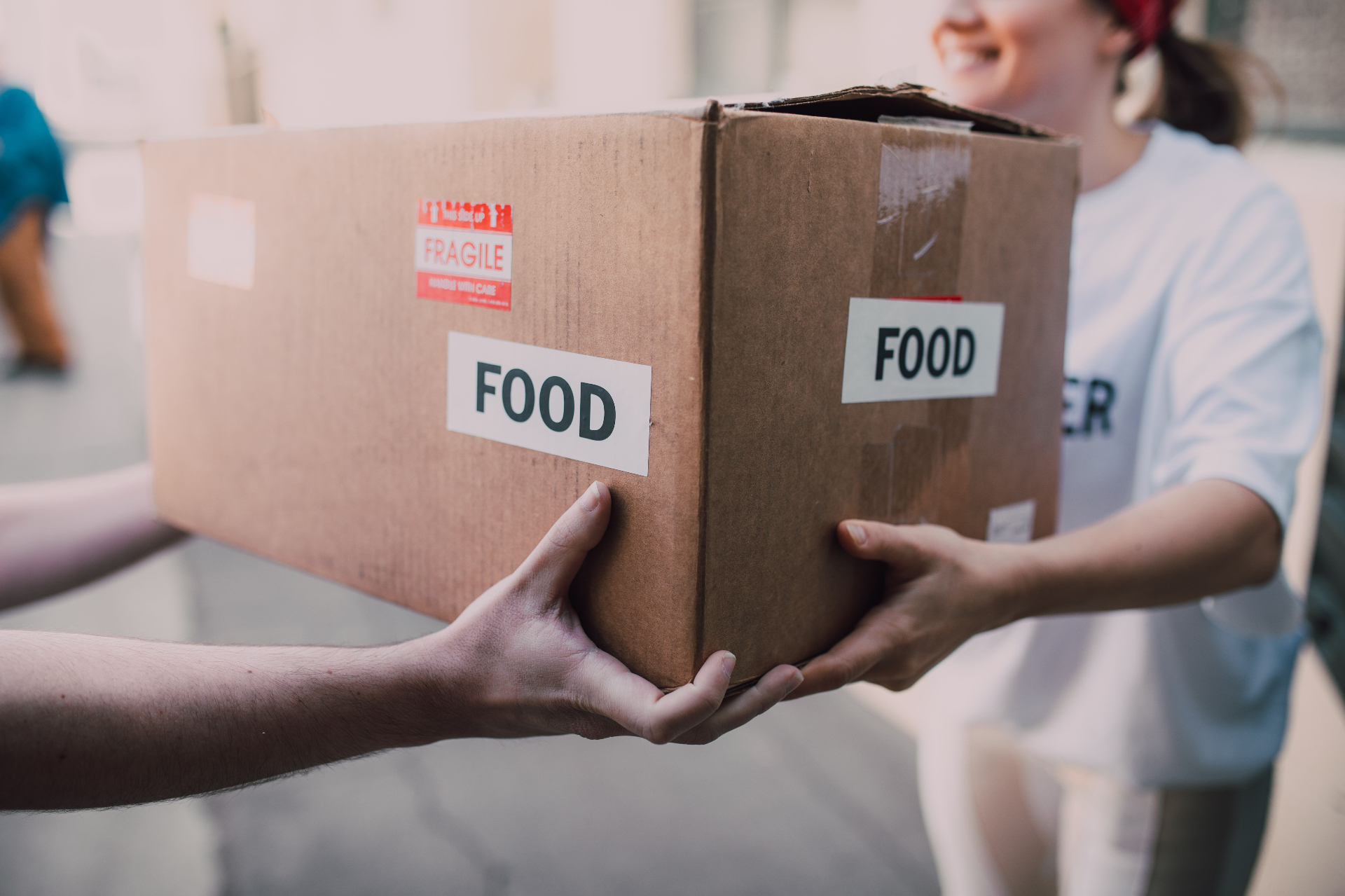 Volunteers handing over a box of food to a family